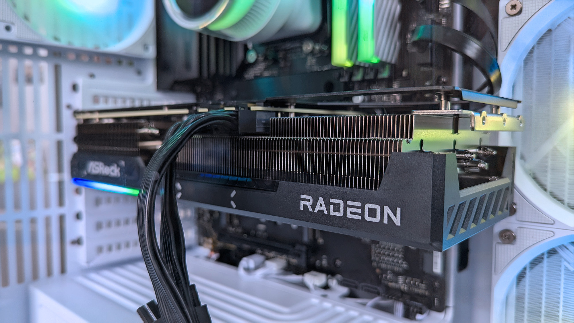 A close-up of a Radeon graphics card inside an iBUYPOWER RDY Trace X R01 pre-built gaming PC with RGB lighting. The card is prominently installed, showing cooling fins and power cables.