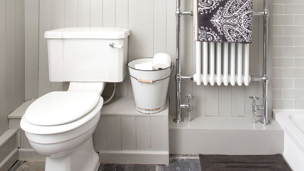 White bathroom with toilet and radiator