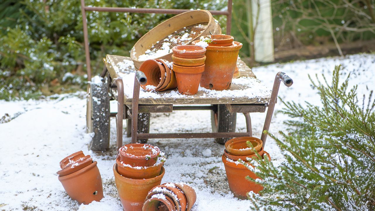 Terracotta plant pots and sifter on cart in the snow