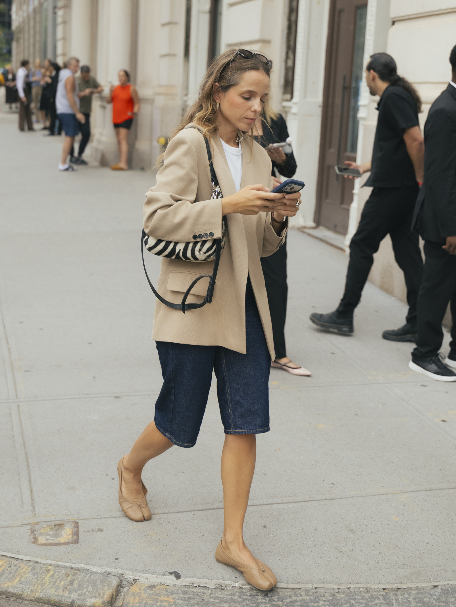 Woman wearing blazer, T-shirt, jorts, and flats