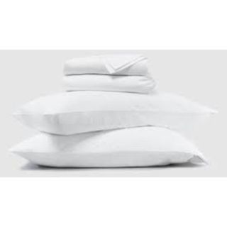 A pile of bedding. Two pillows on the bottom with two folded sheets stacked on top in white