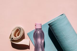 A yoga mat, water bottle and yoga belt.