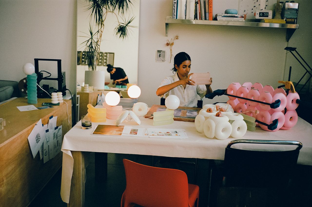 Two young artisans at work in their creations-filled, naturally lit studio.