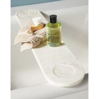 white marble bath caddy with curved design and beauty bits on top