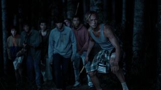 The Wilds season 2's new boy stalk through the woods at night.