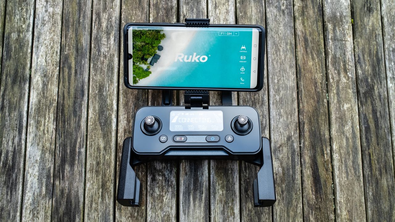 Ruko F11GIM2 Drone - controller with mobile phone attached above.