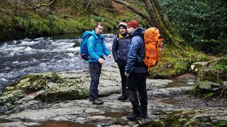 Survival skills and gadgets 101: three men prepare to cross a fast-flowing river during a survival training exercise