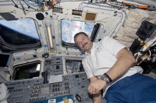 Scott Altman, seen with the Hubble Space Telescope outside of the window, on space shuttle Atlantis during STS-125 in 2009.