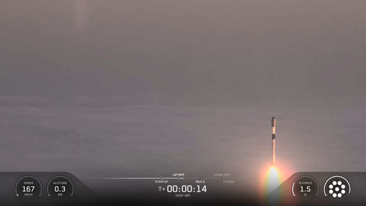 A SpaceX rocket rises out of the clouds and fog during a classified launch to space.