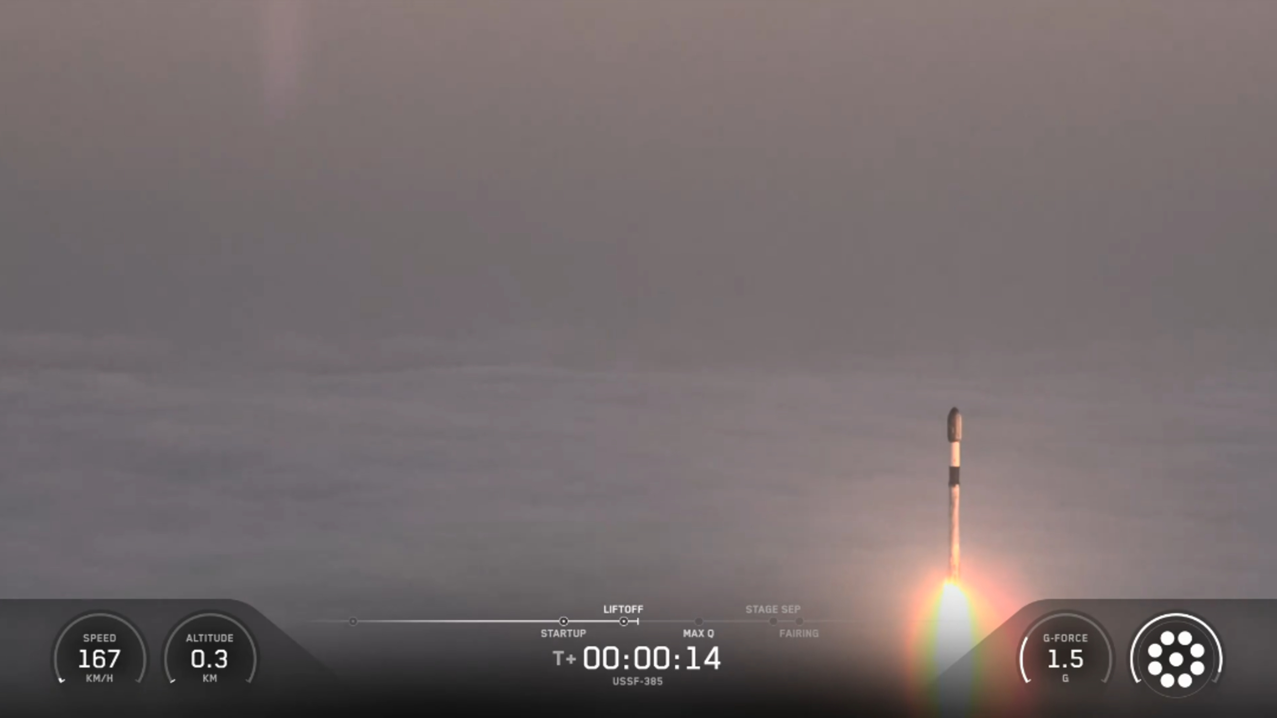 A SpaceX rocket rises out of the clouds and fog during a classified launch to space.