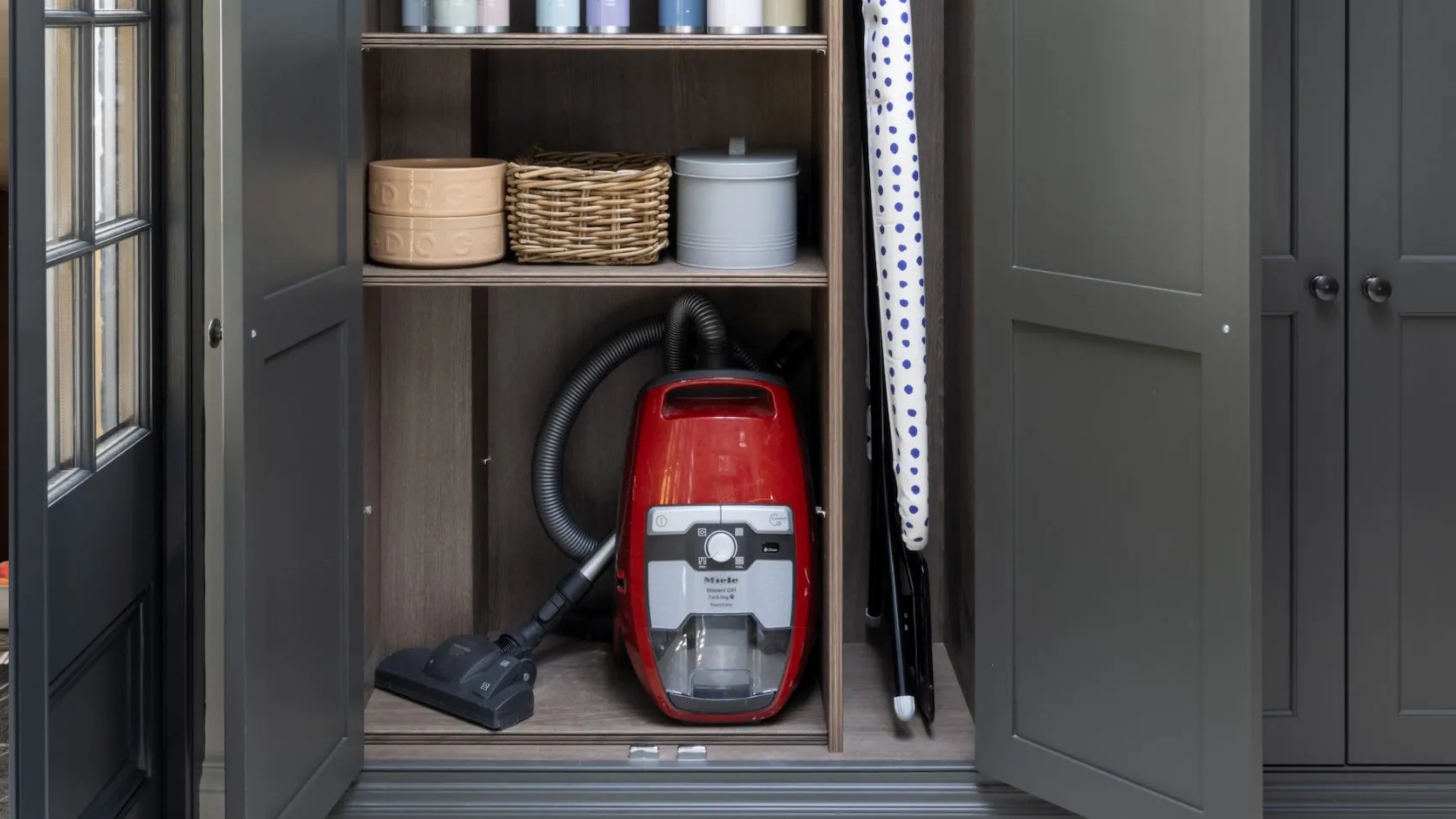 a vacuum cleaner in the base of a cabinet