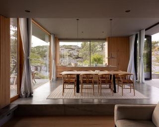 Cabin Lillesand, a norwegian summer house out of wood and its timber interior looking out to waterside nature views through large windows