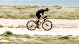 New Pinarello Grevil being riden fast along a gravel track beside water