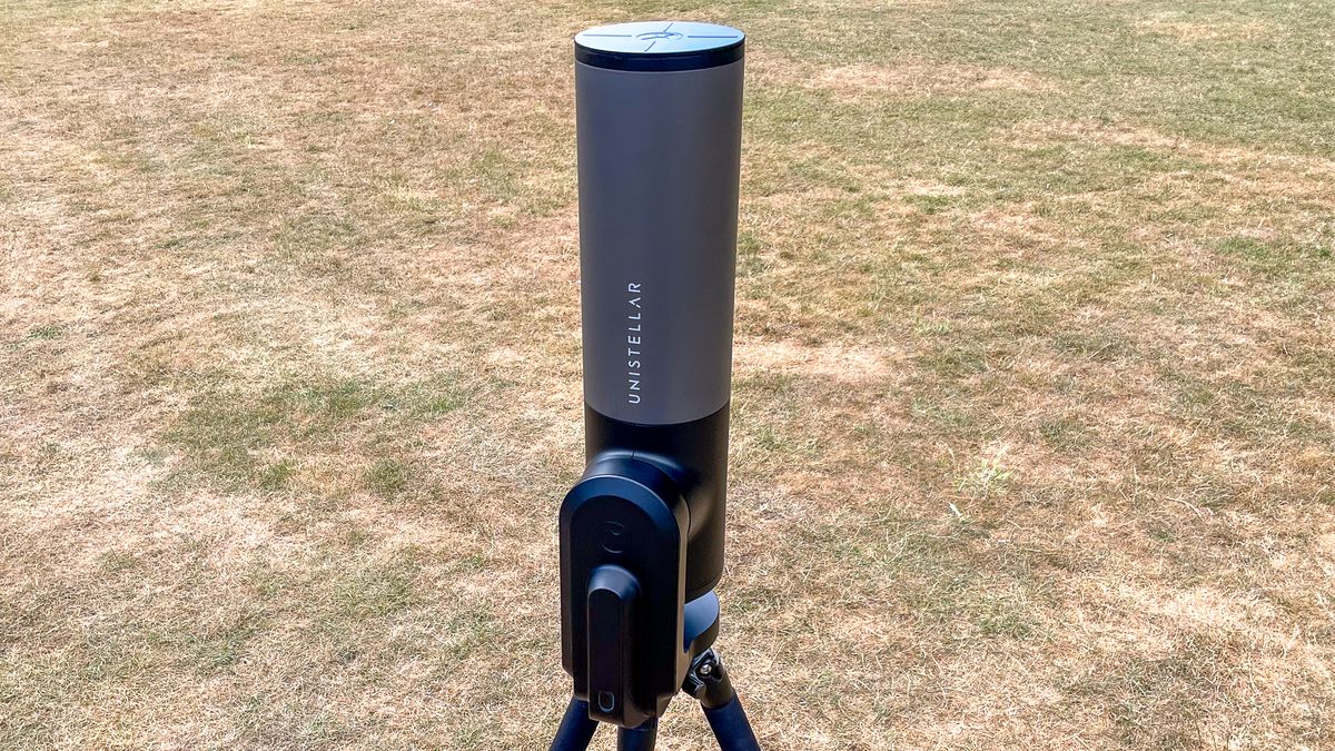 The Unistellar eVscope 2 pointing straight up with grass in the background.