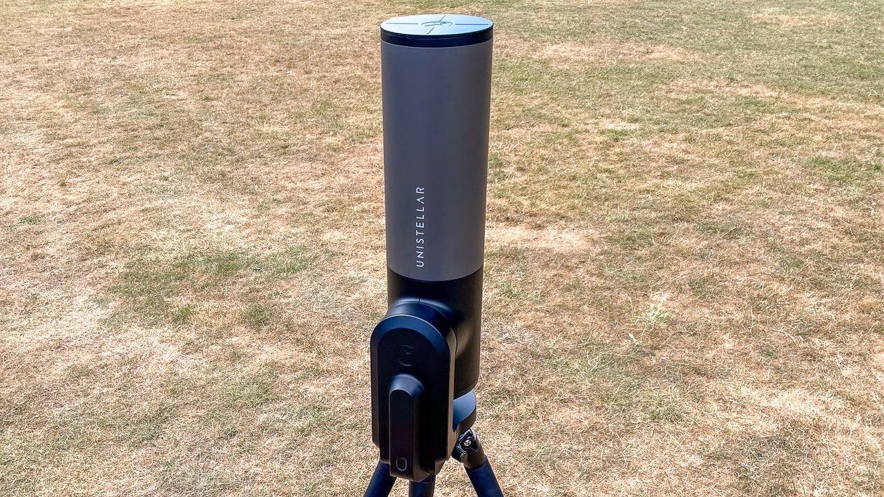 The Unistellar eVscope 2 pointing straight up with grass in the background.