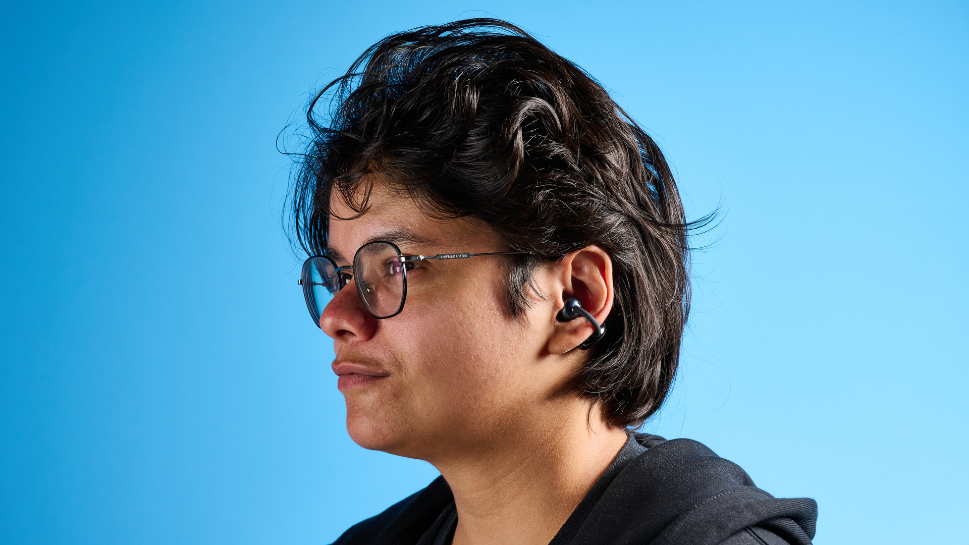 EarFun Clip open-earbuds photographed in front of a blue background.