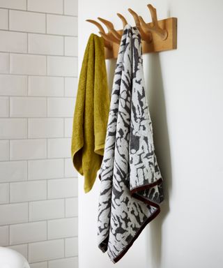 patterned and green towel hanging in bathroom