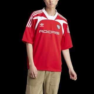 model wears red adidas jersey and khaki pants