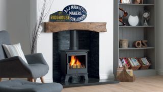 log burning stove in fireplace with timber mantle