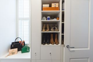A small closet with shoes on a shelf
