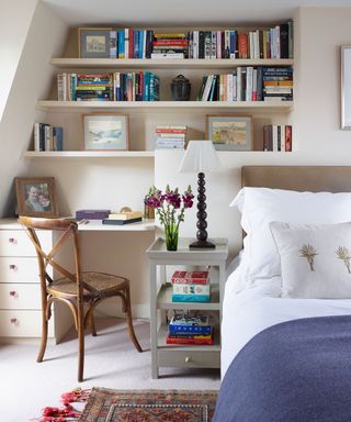 attic bedroom with study table and white bed