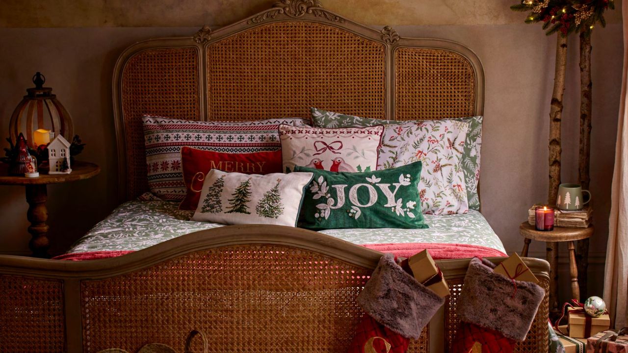 picture of bed with christmas bedding and cusions on it 