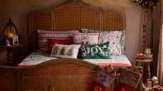 picture of bed with christmas bedding and cusions on it