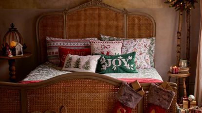 picture of bed with christmas bedding and cusions on it 