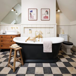 bathroom in loft conversion with chequerboard floor and rolltop freestanding bath in centre ripples