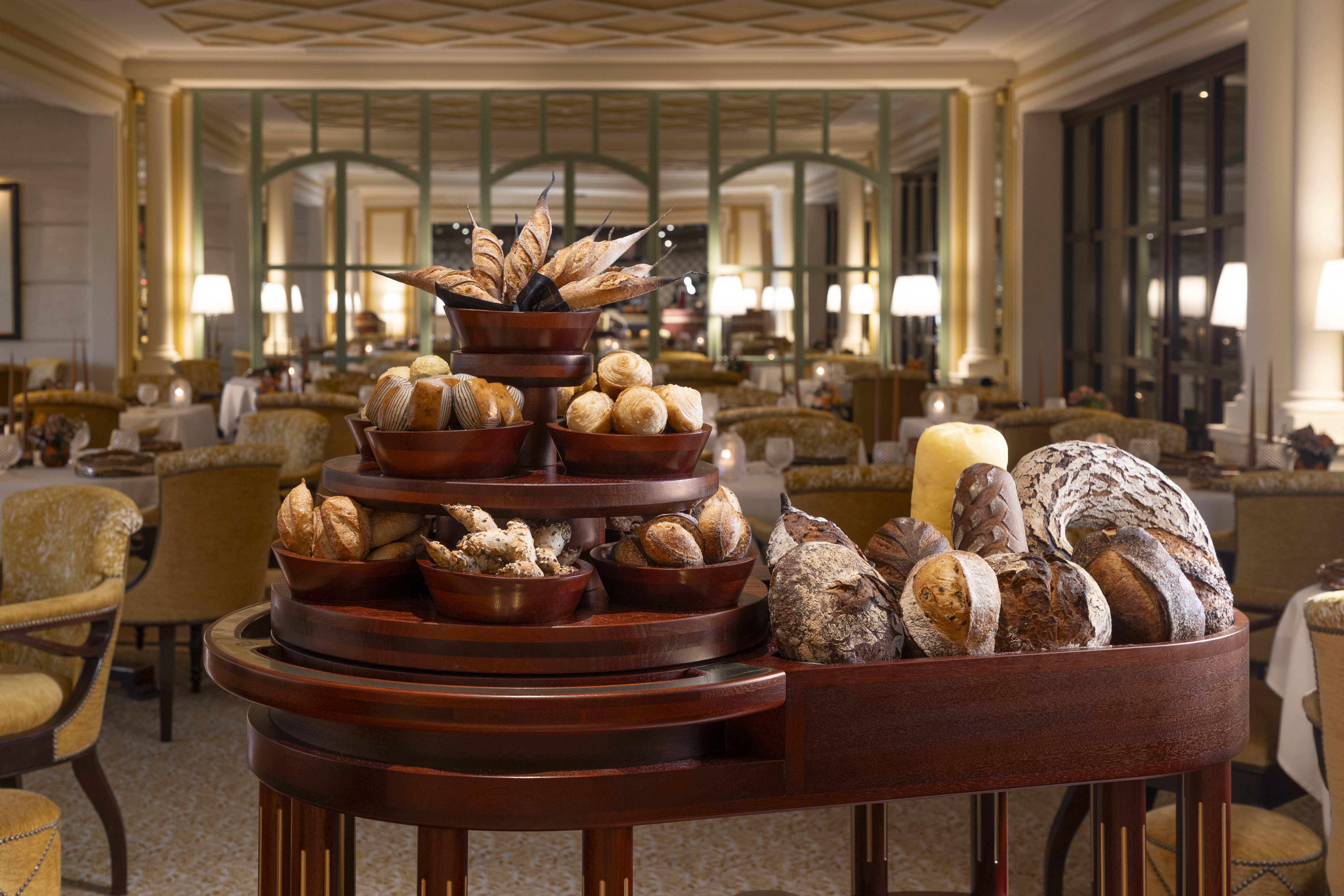 Dark wood bread trolley piled high with loaves of bread in different shapes and sizes