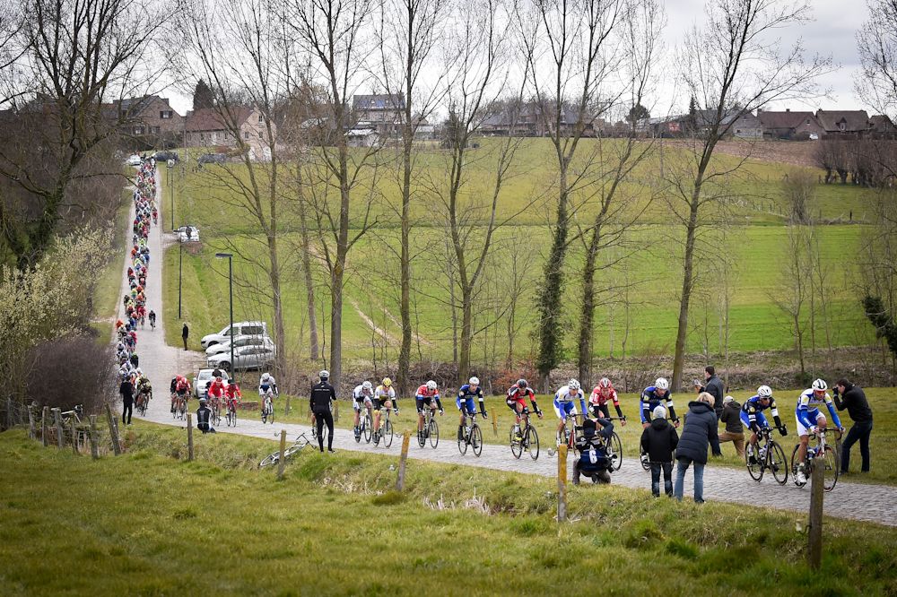 The pack of riders cycles through the Haaghoek during the 71st edition of the 'Dwars Door Vlaanderen' cycling race