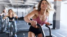 A happy woman at the gym using the air bike