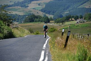 Image shows cyclist getting dropped on a long climb