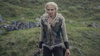 Ciri står på ett grönt fält och håller i en dolk i The Witcher säsong 3.