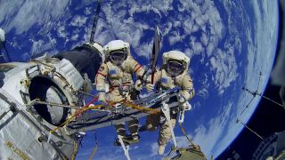 Cosmonauts Oleg Kotov and Sergey Ryazanskiy are seen posing with the Olympic torch during a Nov. 9, 2013 spacewalk outside the International Space Station. The same torch was used to light the Olympic Cauldron in Sochi, Russia.