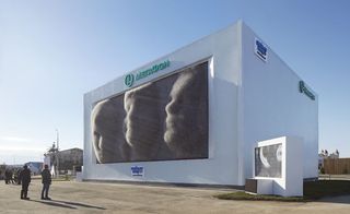 The MegaFaces pavilion. Huge white cube with a kinetic facade that recreates people's faces.