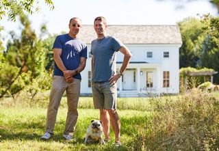 Andrew Goetz, left, and Matthew Malin, right, standing in front of their Hudson Valley home