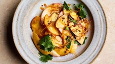 Plate of sliced nectarines with ginger and chilli dressing and coriander