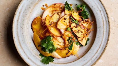 Plate of sliced nectarines with ginger and chilli dressing and coriander