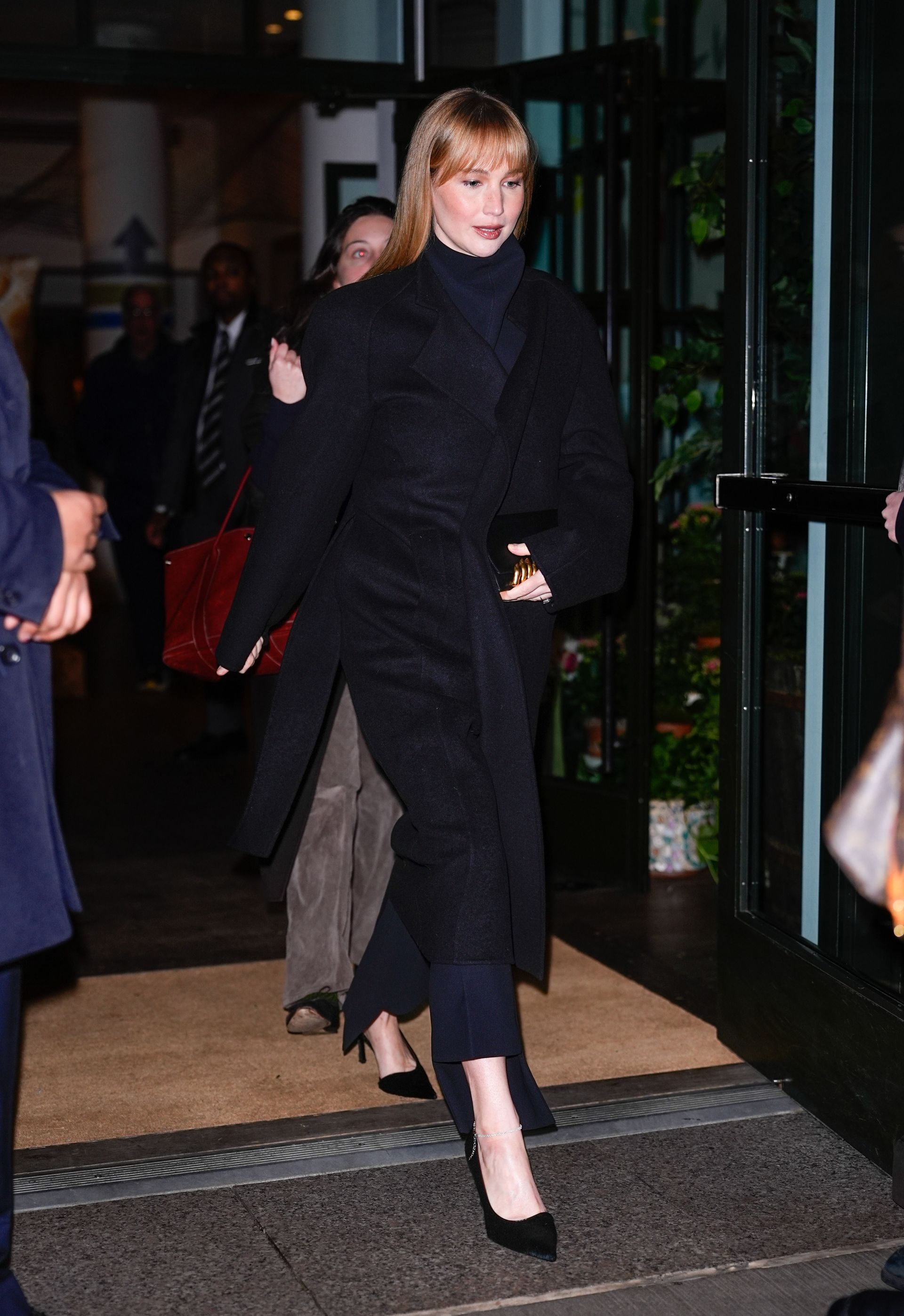 Jennifer Lawrence wears navy tailored trousers.
