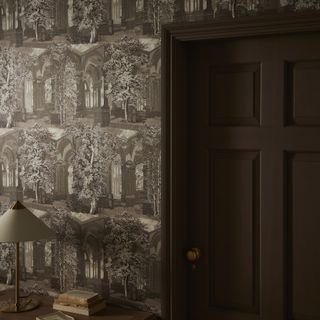 A room with a brown intricate landscape wallpaper and a brown door