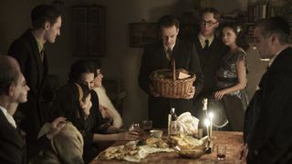Bel Powley and Joe Cole as Miep and Jan Gies at a candlelit supper in A Small Light