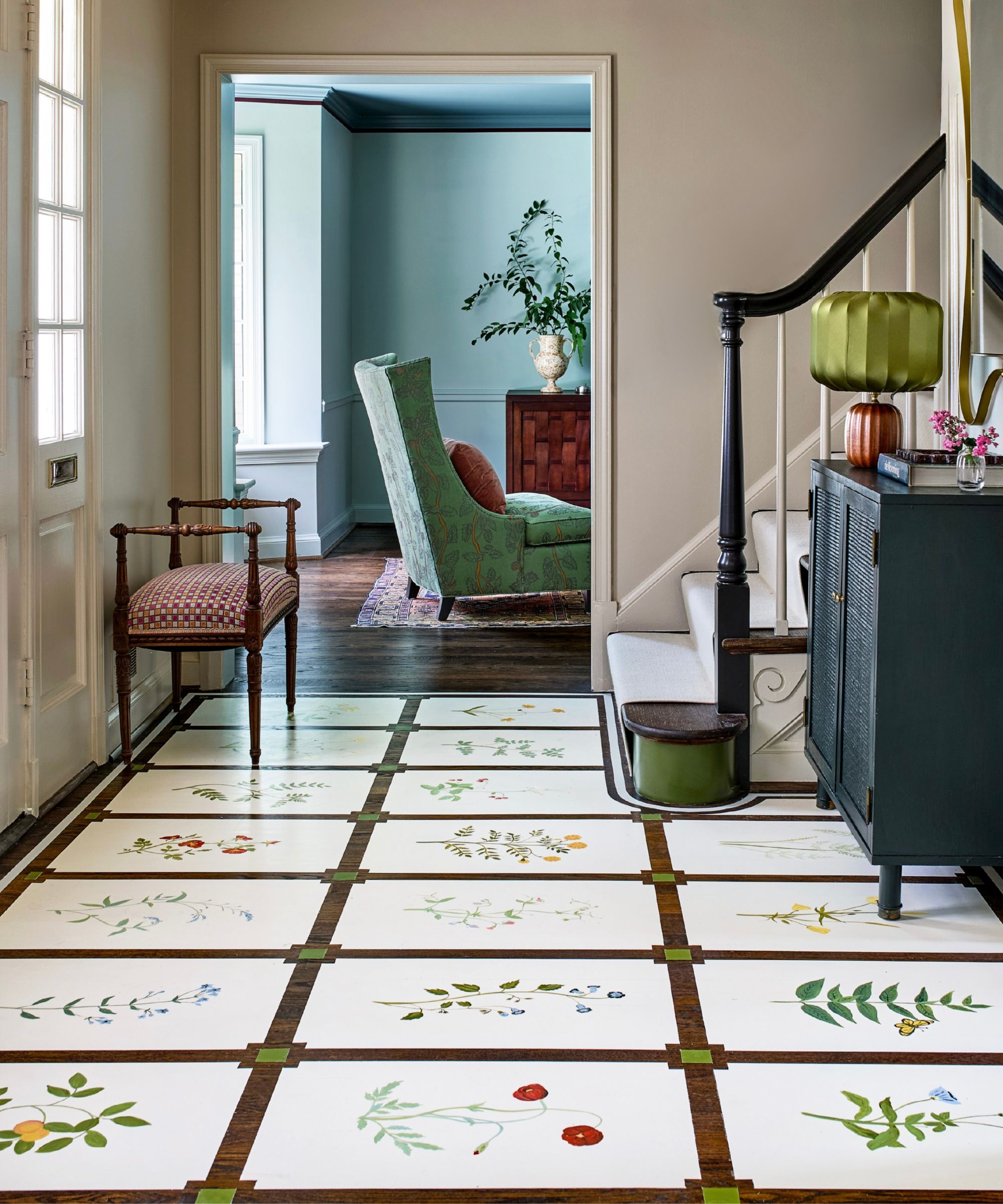 Entry hallway with decorative hand-painted botanical floor panels arranged in a geometric grid.