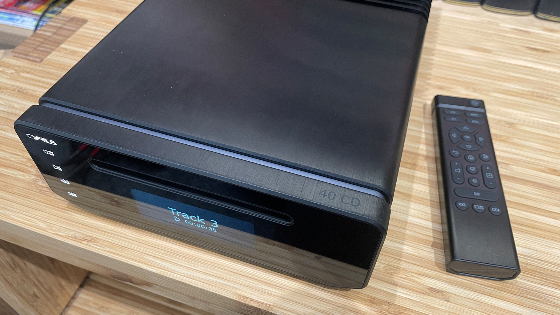 Cyrus 40 CD CD player on wooden hi-fi rack with remote next to it