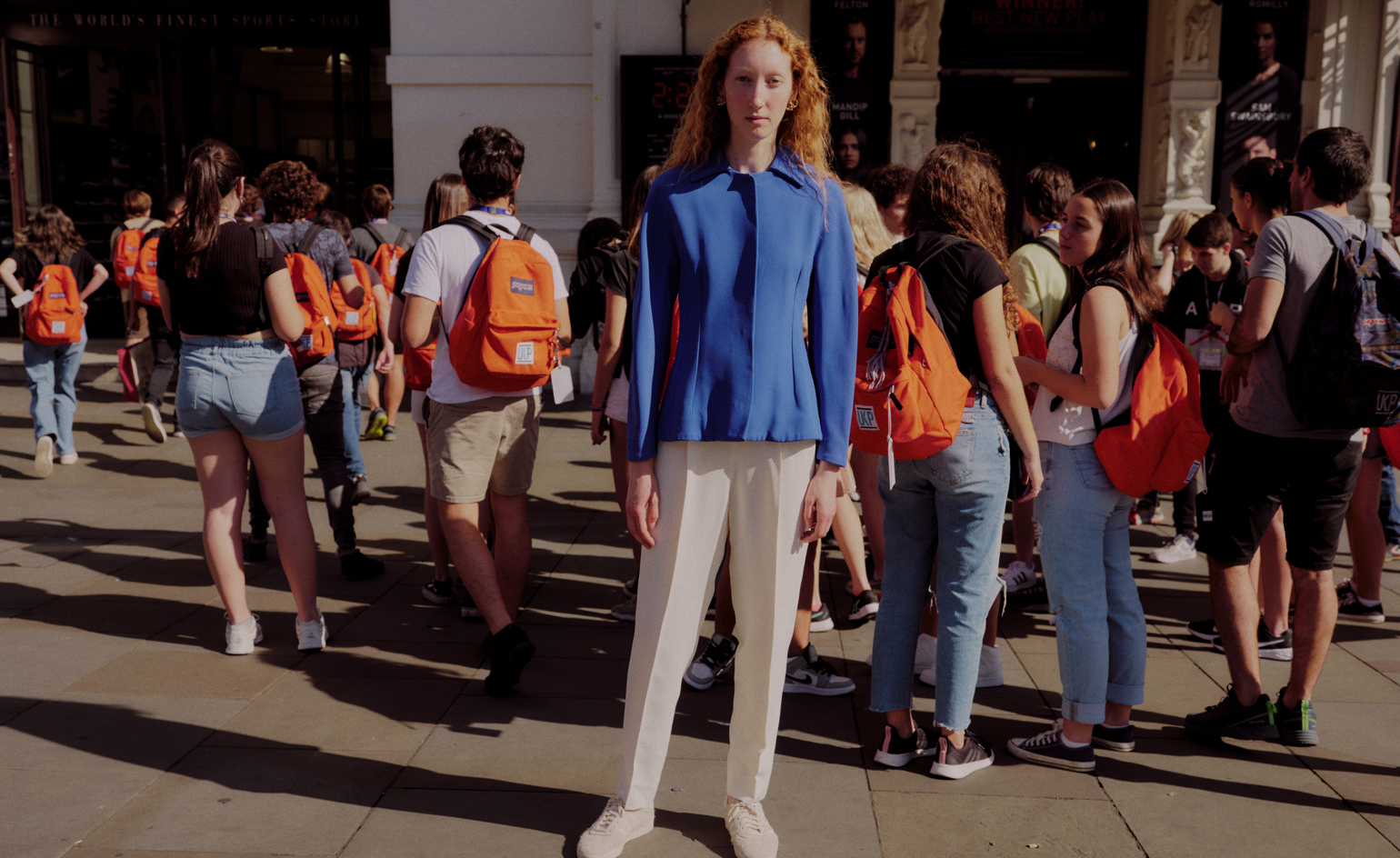 woman in the city wearing jewellery, with tourists behind