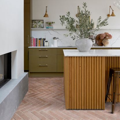 Olive green kitchen with terracotta floor tiles