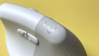 The Logitech Lift for Mac mouse against a yellow background.