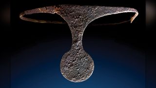 The silver diadem could have been worn upward or downward, although it was found positioned downward on the woman's head in this burial.