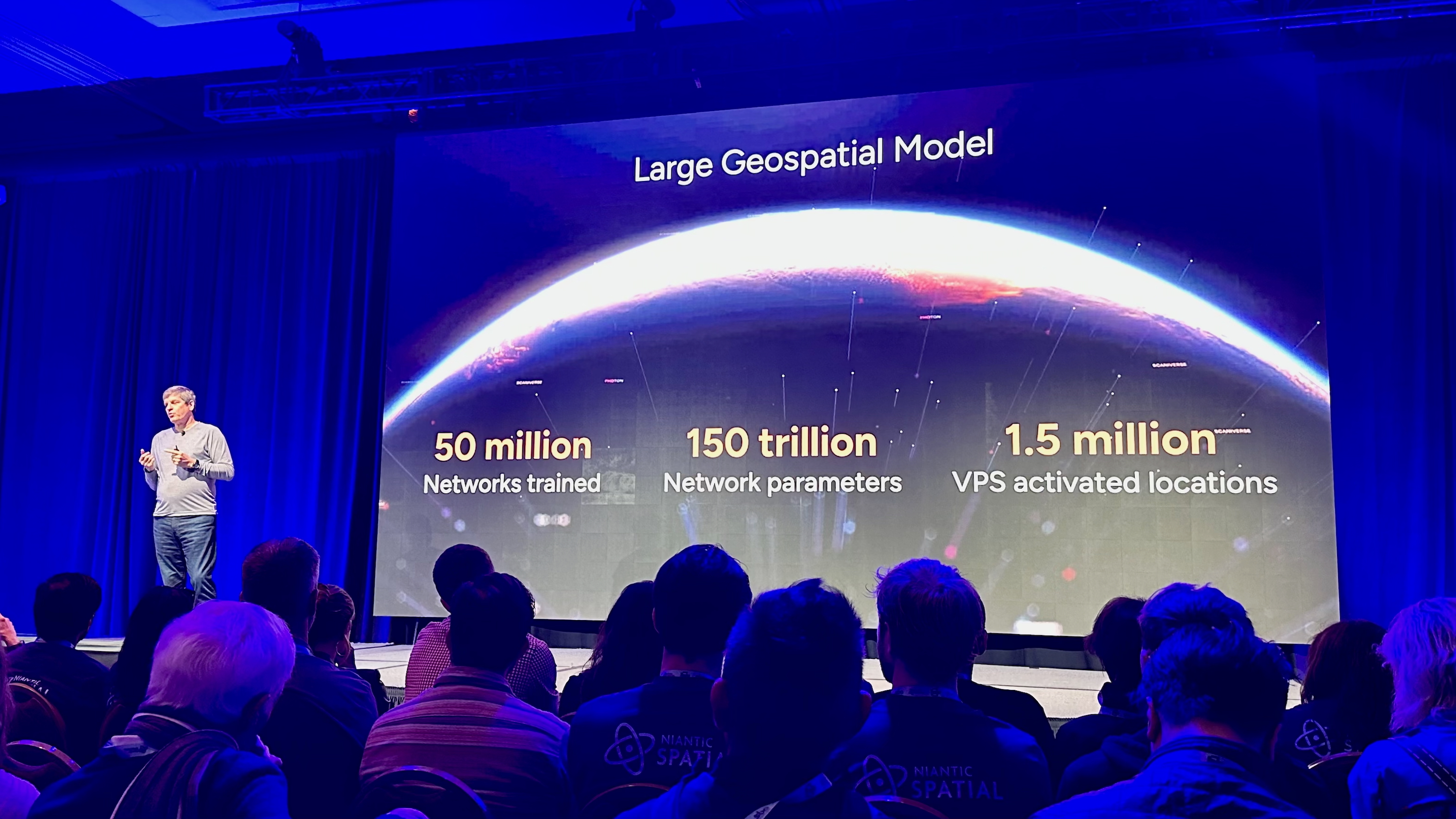 A Niantic Spatial rep describing their new geospatial model on stage at AWE 2025 for the panel "Niantic Spatial: Transforming How We Understand the World Through Geospatial Intelligence."