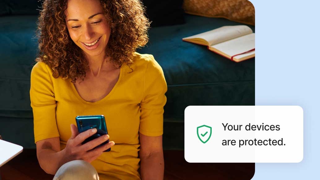 A woman looking at her phone. Next to her is an alert: "Your devices are protected."